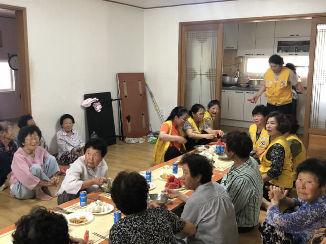 12일 적십자봉사회 회원들이 마을 어르신들과 같이 점심을 먹고 있다.