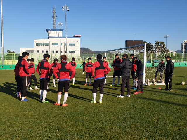 경남FC 김종부 감독이 14일 함안운동장에서 선수들과 전술을 논의하고 있다.