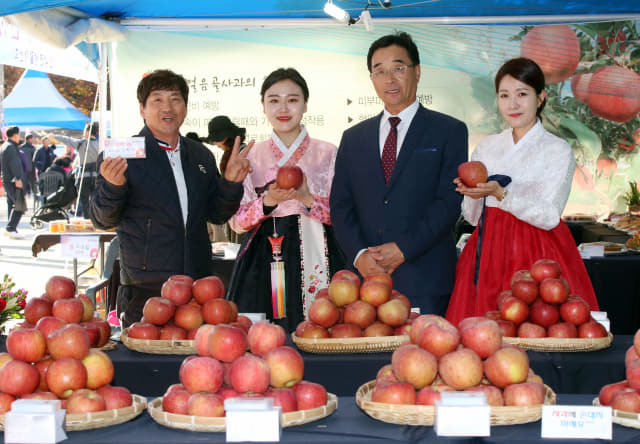 얼음골 사과축제 관계자와 홍보대사가 사과품평회에 출품한 사과를 들어 보이고 있다.(지난해 밀양얼음골 사과축제)