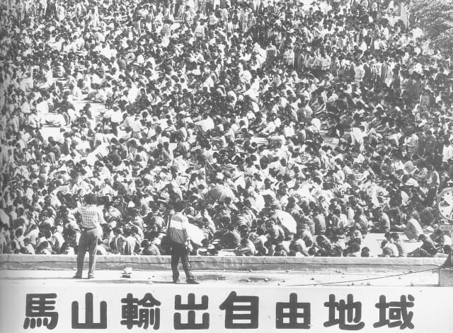 1989년 4월 마산자유무역지역 후문에서 노동자들이 임금 인상 등을 요구하며 집회를 열고 있다./경남신문 DB/