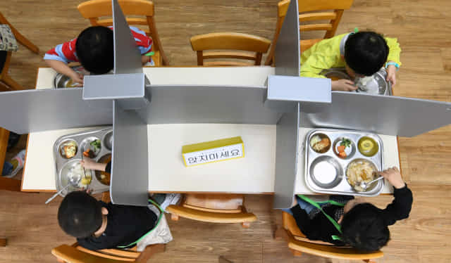 지난해 5월 창원 외동초에서 칸막이가 설치된 급식소에서 점심을 먹고 있는 학생들.