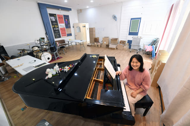 김해시 대청동 ‘음악이 주는 선물’의 이지현 대표가 피아노 앞에서 활짝 웃고 있다.